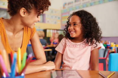 Woman smiling at child in classroom
