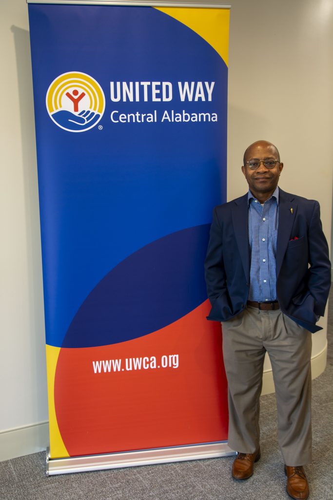 Visiting Allocation Team chair James Mathews stands beside a United Way of Central Alabama banner.
