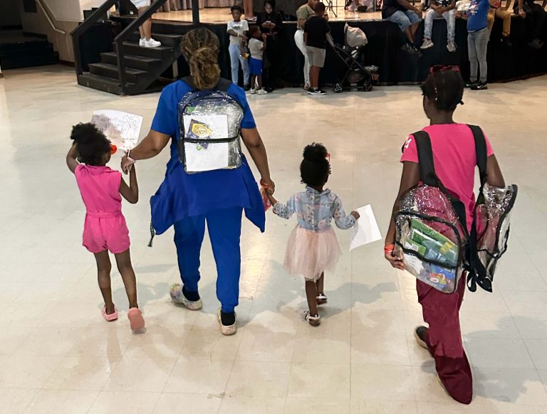 A family enjoying the activities at a back-to-school backpack giveaway event.