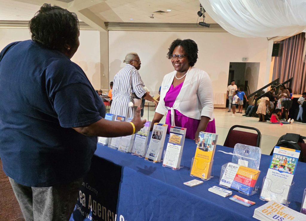The United Way Area Agency on Aging shares information on resources with an attendee at a Fairfield back-to-school event.