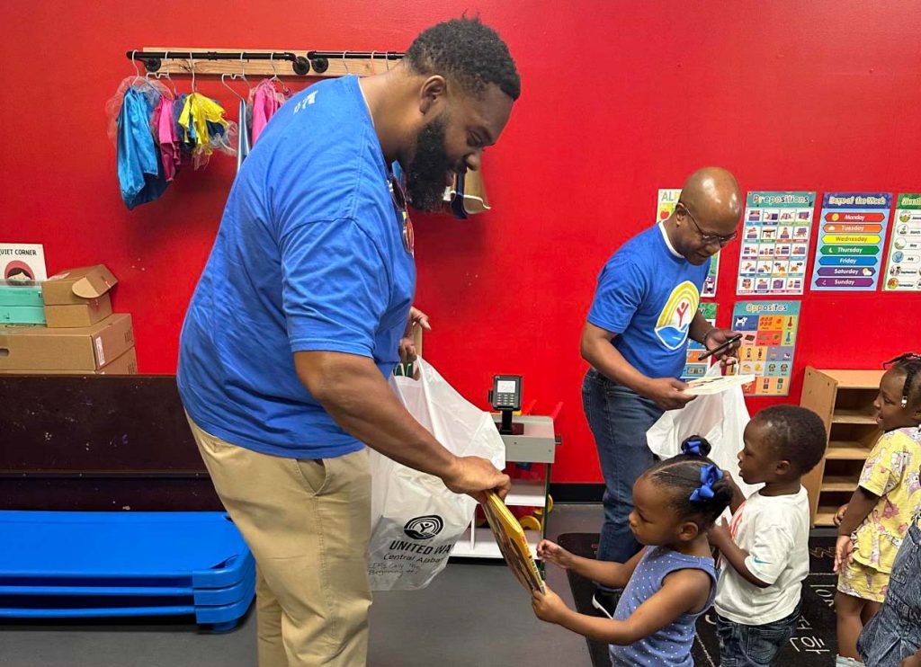 JMDLS members handing out books to children at Tuggle Elementary School