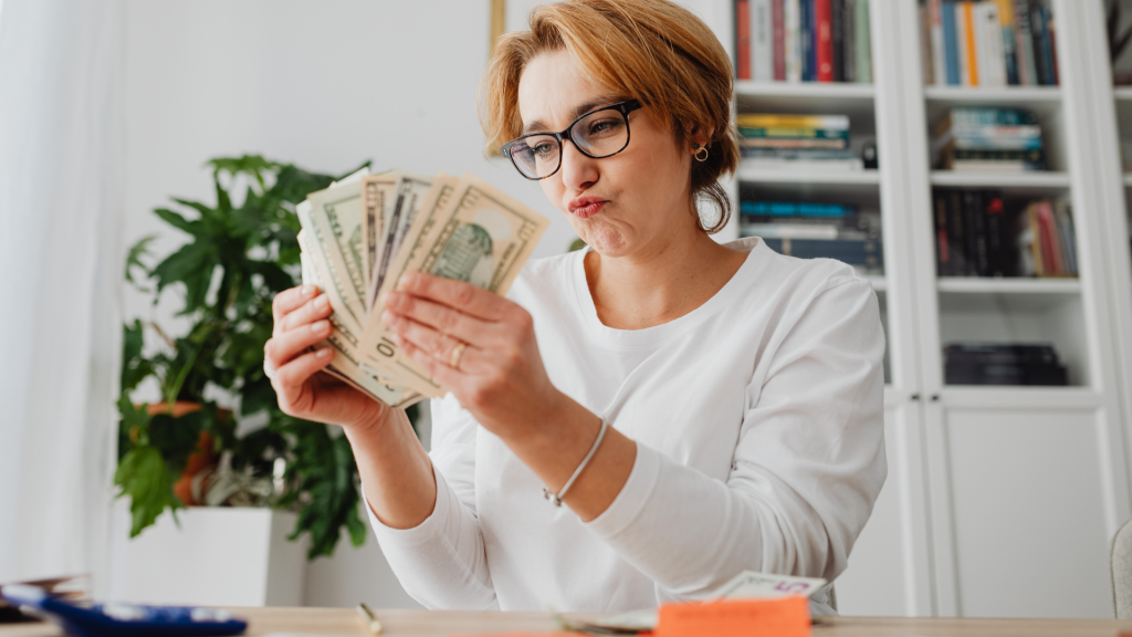 Counting cash at a desk for holiday budgeting and personal finance planning.