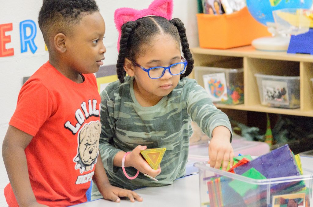 two young children play in a preschool classroom