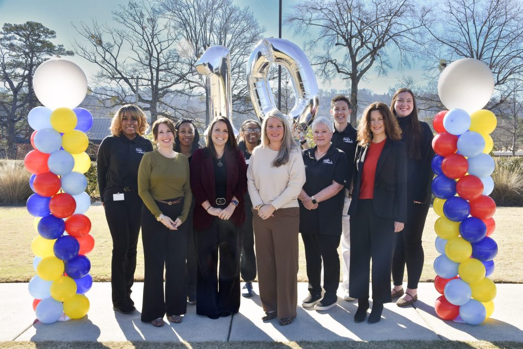 Meals on Wheels staff gather with balloons to celebrate the program's tenth anniversary.