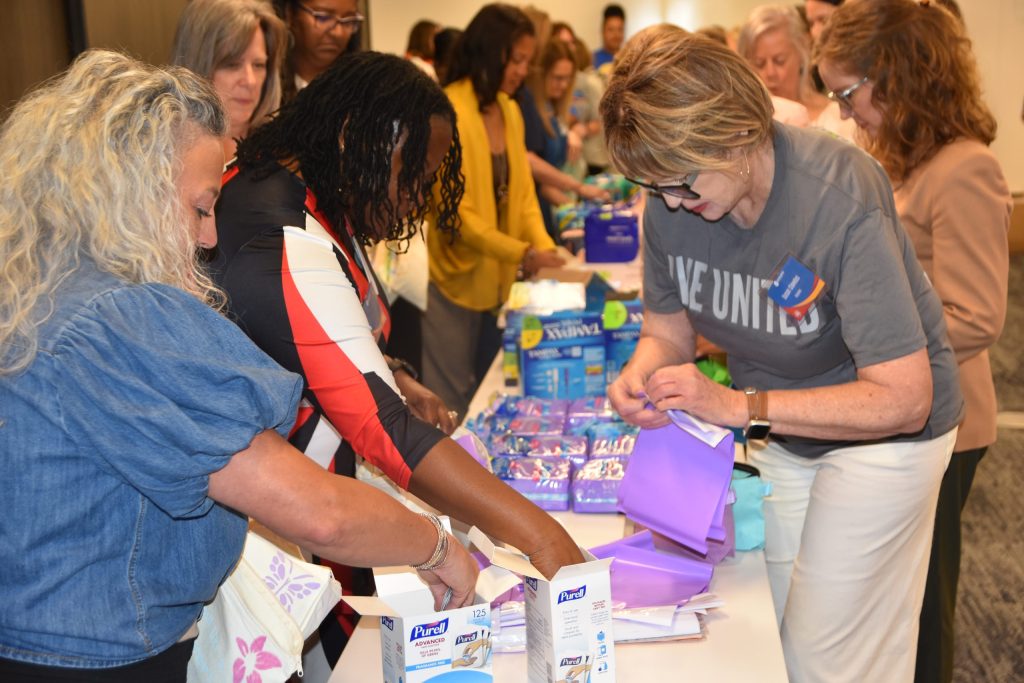 Volunteers assemble donated period supplies into kits for distribution across Central Alabama.