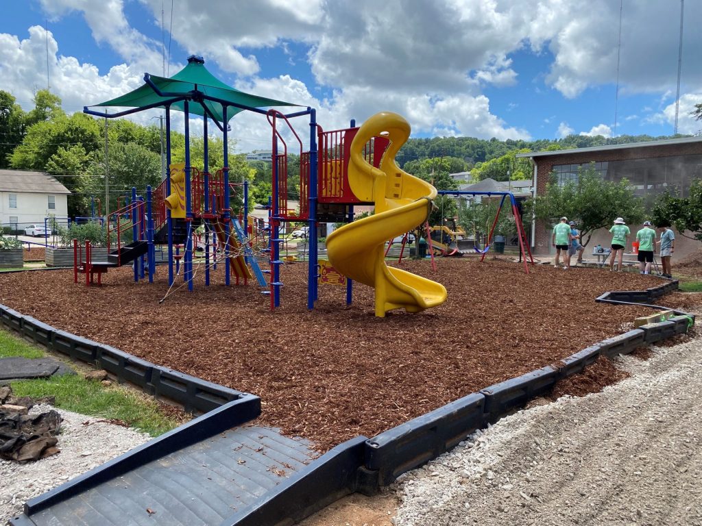 Volunteers working to get an elementary school playground ready before school starts