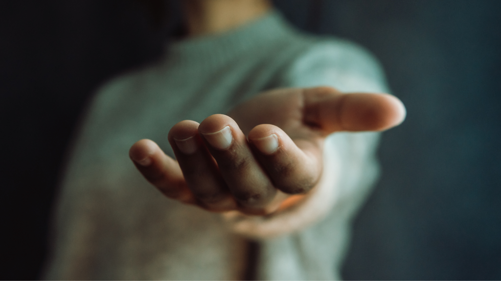 Outstretched hand reaching forward in a gesture of support and connection.
