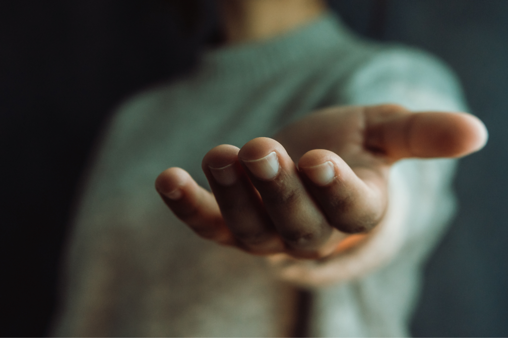 Outstretched hand reaching forward in a gesture of support and connection.