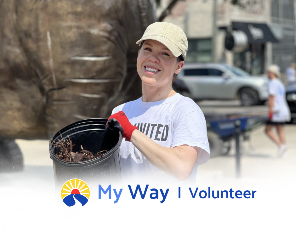A smiling United Way volunteer holds a bucket of mulch during an outdoor community cleanup, with the My Way Volunteer logo below.