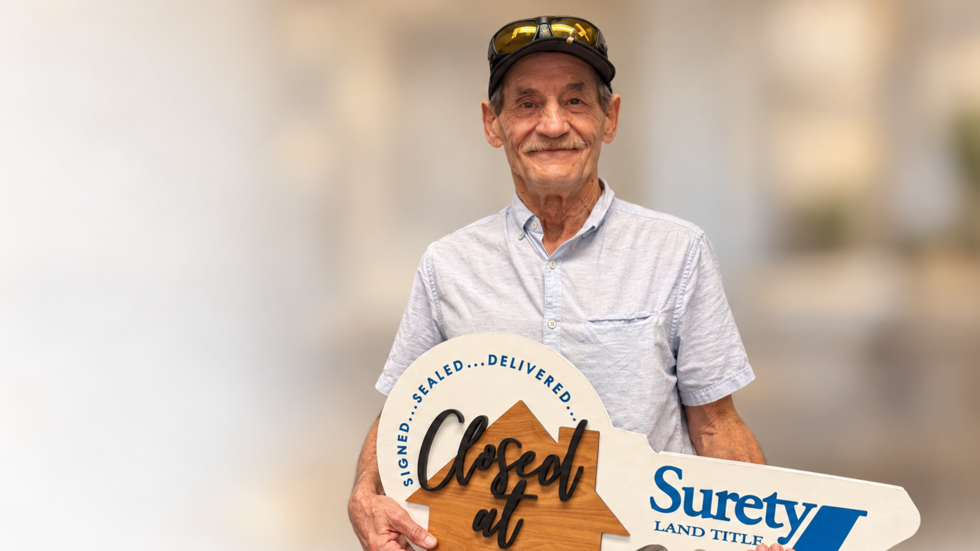 Priority Veteran client Bobby Burr smiles while holding an oversized ceremonial house key.