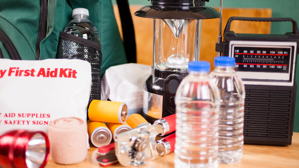 A well-stocked emergency preparedness kit, including a first aid kit, bottled water, flashlight, batteries, lantern, radio, and essential supplies for weather emergencies