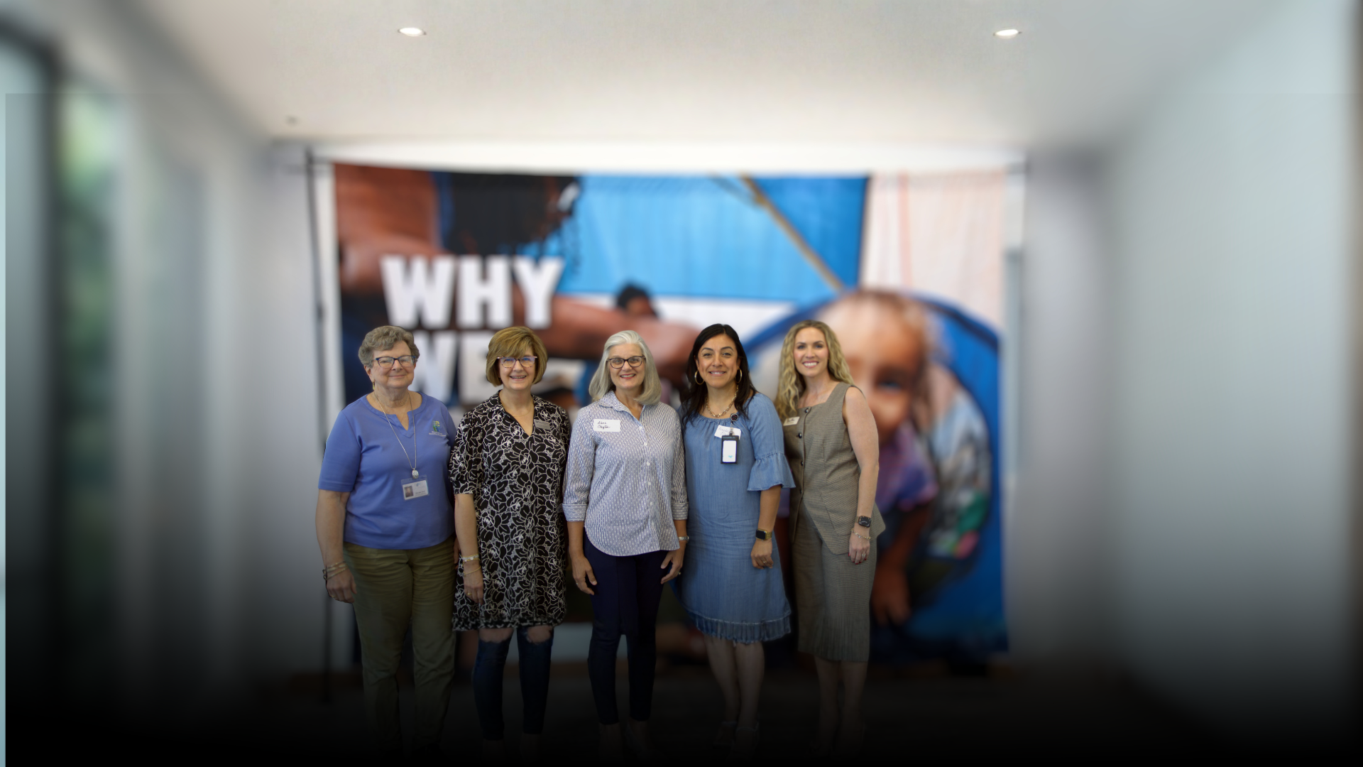 Five Blount County Advisory Board members pose for a group photo in front of a United Way of Central Alabama community impact display.